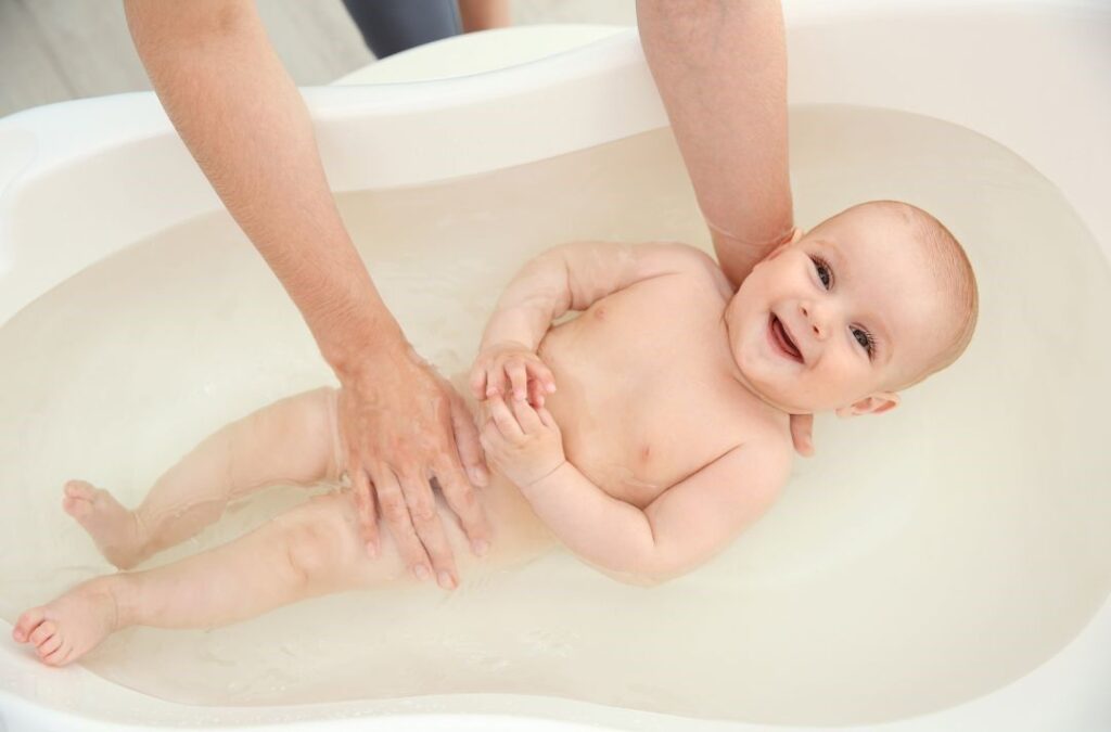 bebe en bañera sonriendo